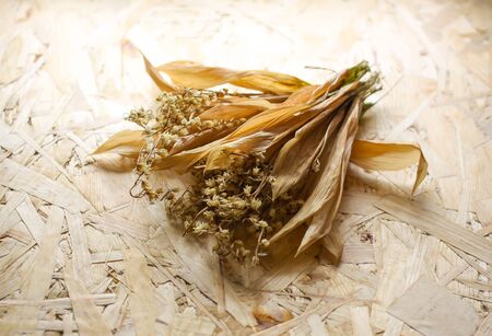 Dried lily of the valley flowers bouquet on rough wooden background.の写真素材