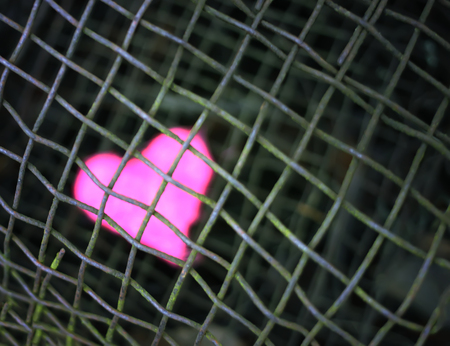 Colorful decorative heart on old rustic iron sieve background.の写真素材