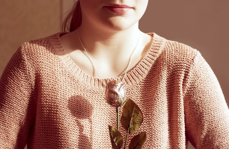 Detail of portrit of a young girl with artificial roseの写真素材