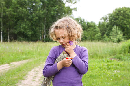 Adorable little girl with curly hair walking outdoorsの写真素材