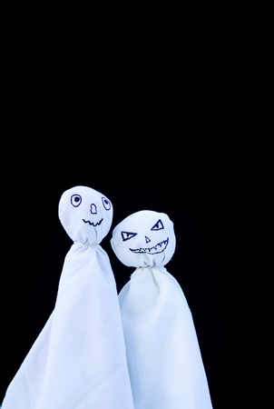 Decoration for Halloween. Two ghost figures on black background. Handmade decor for party.の写真素材