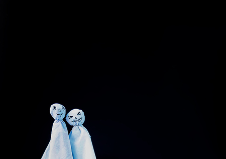 Decoration for Halloween. Two ghost figures on black background. Handmade decor for party.の写真素材