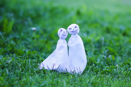 Decoration for Halloween. Two ghost figures on nature background. Handmade decor for party.