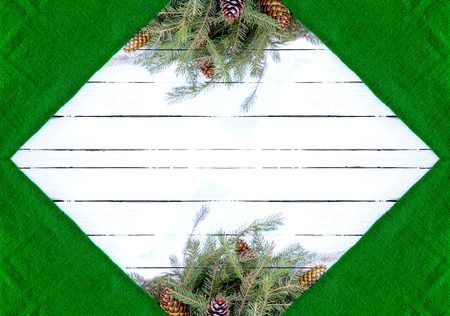 Christmas composition with fir branches and cones on white aged wooden background. Green woolen texture. New Year festive design template. Symmetrical frame. Decorative border with empty space for text.の写真素材