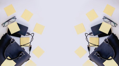 Symmetrical banner composition with black bag, external hard disks, colorful paper empty stickers and glasses. Business details.の写真素材
