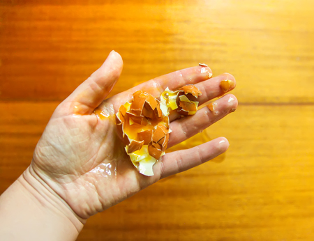 Raw smashed egg in a hand.の写真素材