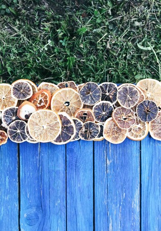 Christmas and New Year winter holiday composition with dried orange slices on blue aged wooden boards. Festive frame.の写真素材