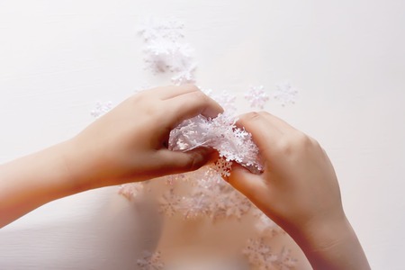 Child holds decorative paper snowflakes in hands.の写真素材