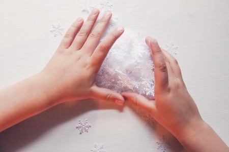 Child holds decorative paper snowflakes in hands.の写真素材