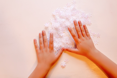 Child holds decorative paper snowflakes in hands.の写真素材