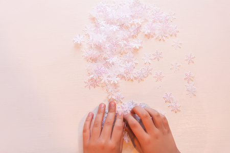 Child holds decorative paper snowflakes in hands.の写真素材
