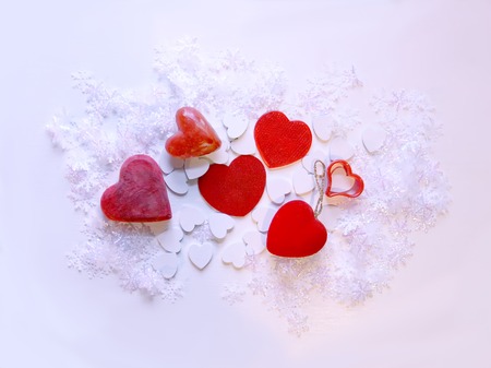 Artificial snowflakes and red decorative hearts on white softの写真素材