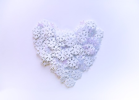White artificial snowflakes in a shape of heart on soft blueの写真素材