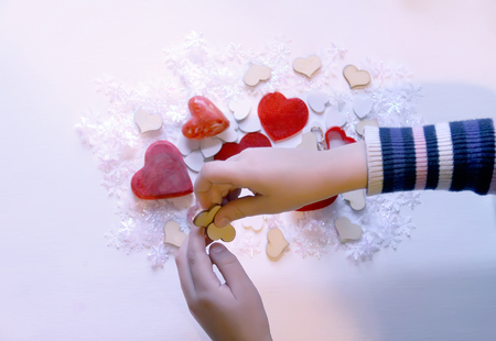Small colorful hearts in child's hands. Gift decoration process.の写真素材