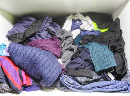 Home wardrobe with different clothes in disorder. Small space organization.の写真素材
