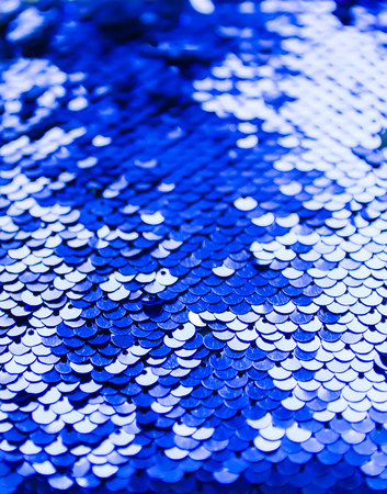 Bright shiny rugged texture of colorful sequins in blue and purple colors. Fashion fabric background.の写真素材