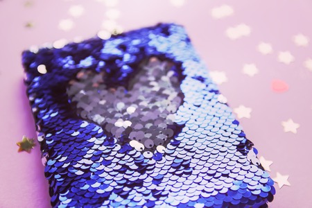 Bright composition of fashion stationery. Glitter sequins notepad and decorative tinsel. Different objects on soft pastel background. Flat lay, top view.の写真素材