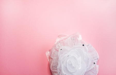 White ribbon bow on soft pink background. Festive decorative element.の写真素材