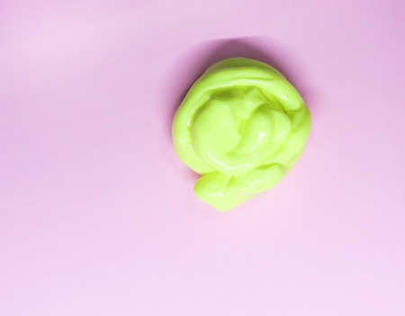 Sample of yellow slime on soft pink background.