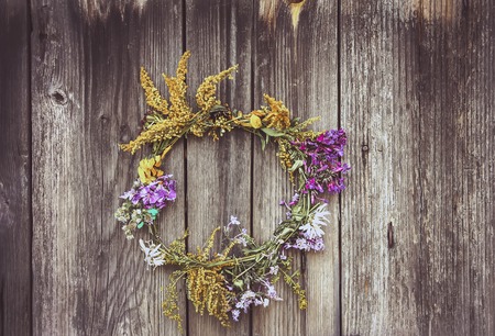 Wreath of wild flowers on the old wooden doorの写真素材