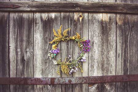 Wreath of wild flowers on the old wooden doorの写真素材