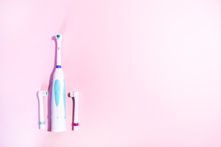 Two electrical toothbrushes on a soft light pinkの写真素材