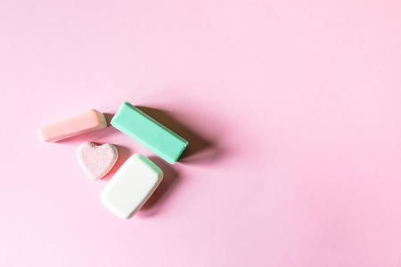 Different homemade coloful soap on soft pink background.