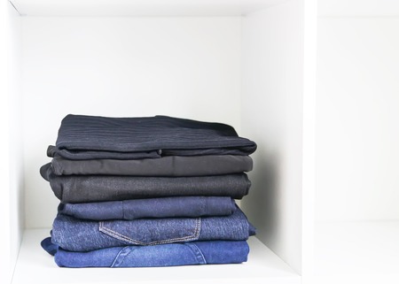 Home wardrobe with different clothes. Small space organization. The contrast of order and disorder.の写真素材