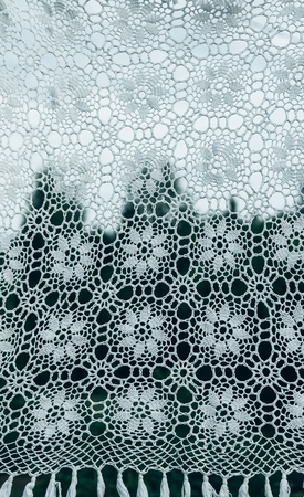 White crocheted handmade vintage tablecloth on nature background outdoorsの写真素材