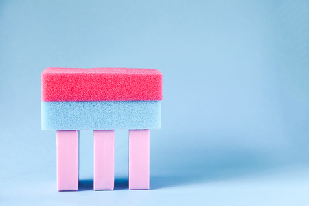Colorful washcloths and bars of soap on a soft blue background. Accessories for body care and...