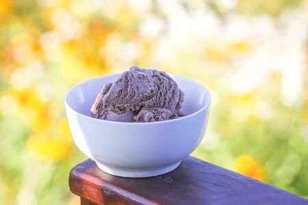Melting chocolate ice cream in a white ceramic cup.