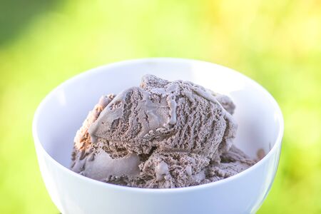 Melting chocolate ice cream in a white ceramic cup.