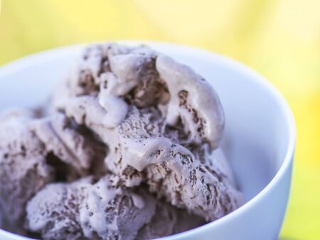 Melting chocolate ice cream in a white ceramic cup.