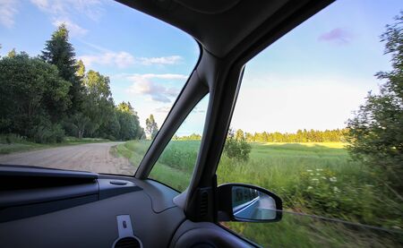 View of forest country road through car glass during the travel