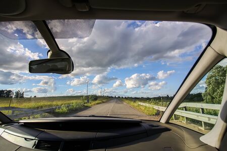 View of forest country road through car glass during the travelの写真素材