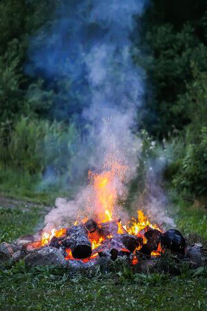 Bonfire at a camp in summer evening outdoors.の写真素材