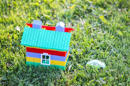 Toy house on green summer meadow background.の写真素材