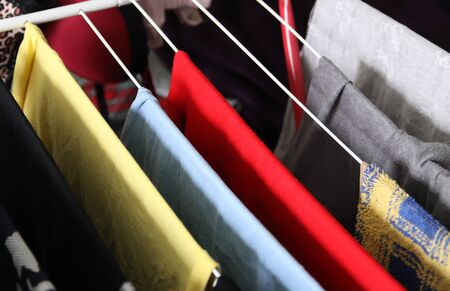Colorful different dress and laundry hanging on a drying rack.