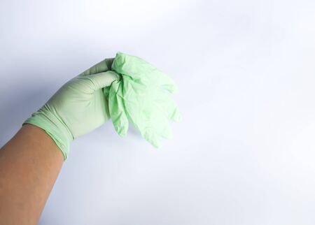 Woman's hand holds the rubber glove.