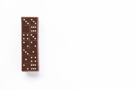 Vintage black domino tiles in the box on white background