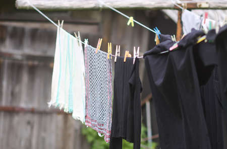 Colorful laundry hanging on the rope outdoors. The process of air drying clothes