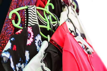 Colorful clothes hanging in disorder in home wardrobeの写真素材