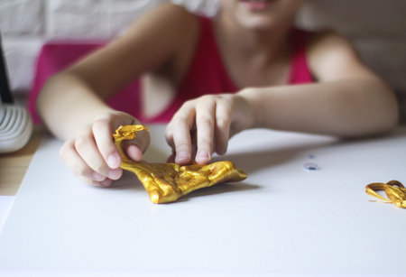 Little girl playing with the gold slime. Sensory activity for child.の写真素材