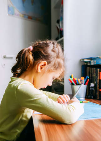 A girl doing her homework at home.の写真素材