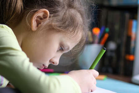 A girl doing her homework at home.の写真素材