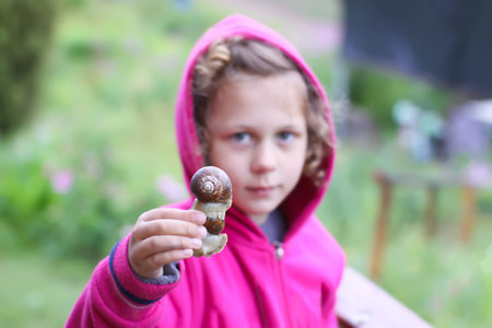 Little girl with snail in her handの写真素材