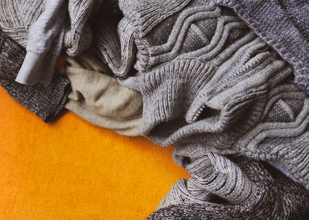 Warm knitted jumpers and sweaters on bright yellow background.の写真素材