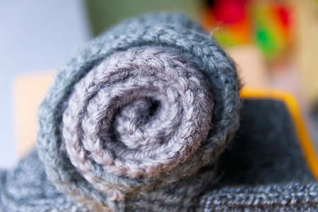 Clothes in cardboard box. Grey trendy fashion colors. Rolled jumper. Home wardrobe compact organizing. Home storageの写真素材