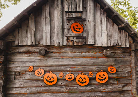 Halloween decor outdoors. Paper pumpkins on wooden building of the bathhouse in village.の写真素材