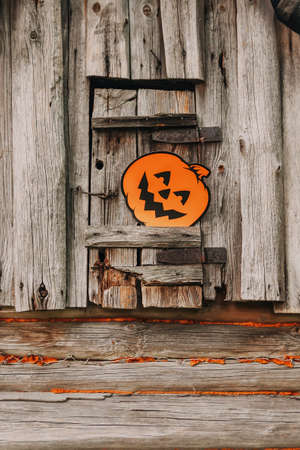 Halloween decor outdoors. Paper pumpkin on wooden building of the bathhouse in village.の写真素材